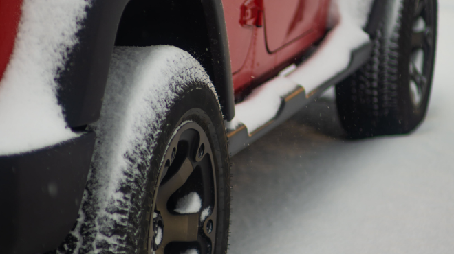 Jeep driving through snow covered road